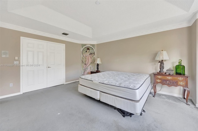 carpeted bedroom with a textured ceiling and a closet