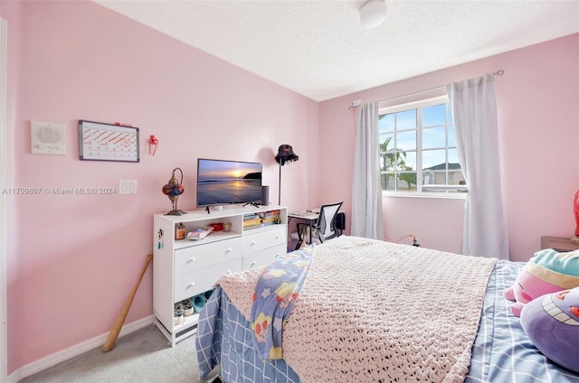 bedroom featuring light carpet and a textured ceiling