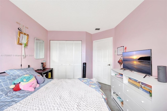 bedroom featuring carpet flooring, a textured ceiling, and a closet