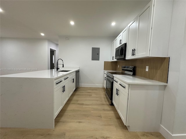 kitchen featuring white cabinetry, sink, light wood-type flooring, and appliances with stainless steel finishes