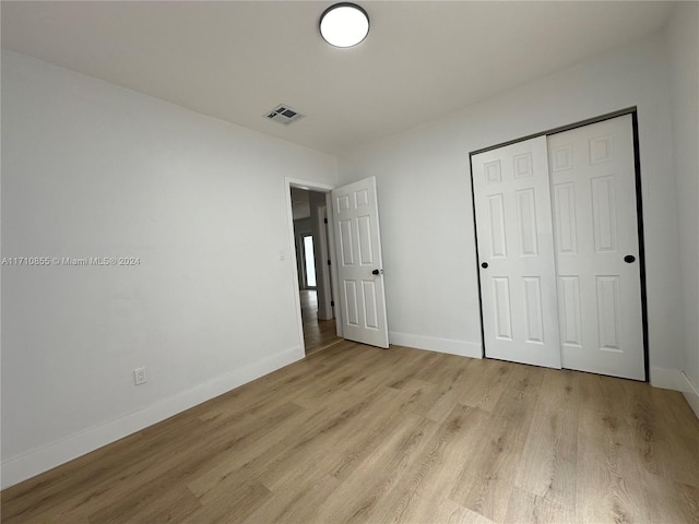 unfurnished bedroom with light hardwood / wood-style flooring and a closet