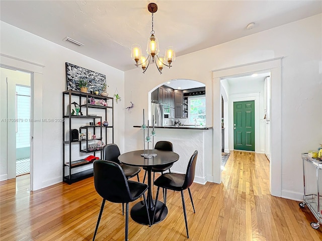 dining area featuring light hardwood / wood-style flooring and an inviting chandelier