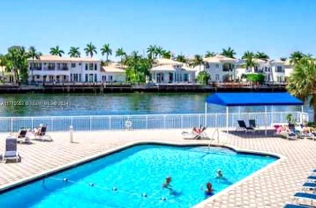 view of swimming pool with a water view and a patio