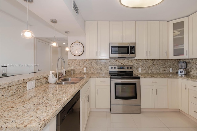 kitchen featuring appliances with stainless steel finishes, sink, light tile patterned floors, decorative light fixtures, and white cabinetry