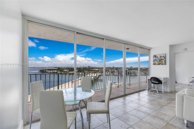 sunroom featuring a water view