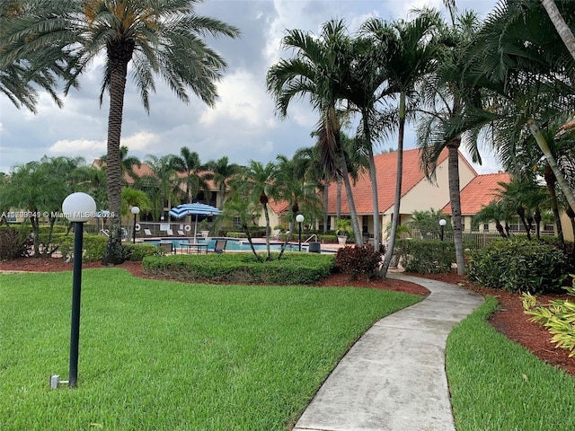 view of property's community with a lawn and a pool