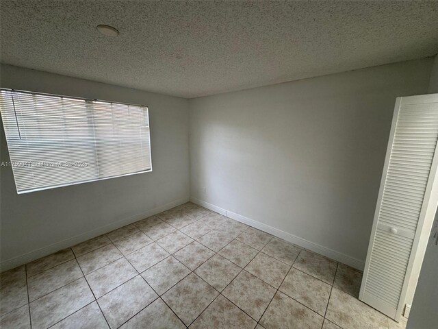 spare room featuring light tile patterned flooring