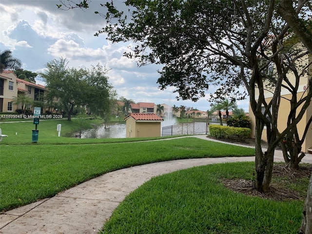 view of community with a water view and a yard