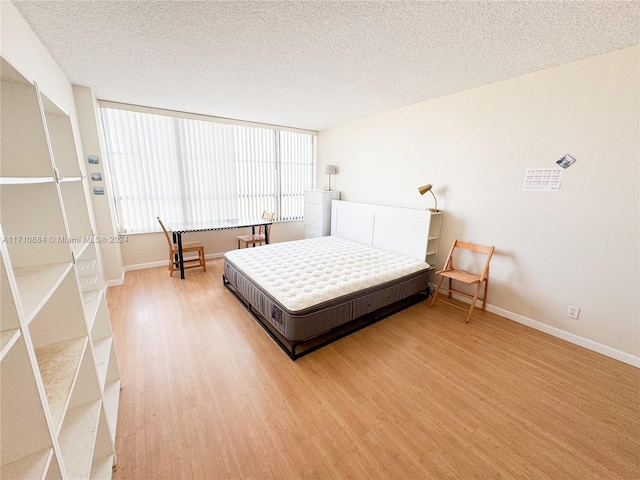 bedroom featuring wood-type flooring and a textured ceiling