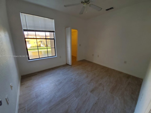 empty room featuring visible vents, baseboards, and ceiling fan