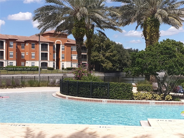 view of swimming pool featuring fence