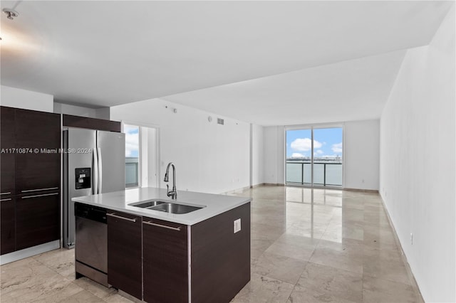 kitchen featuring a center island with sink, dishwasher, dark brown cabinets, and sink