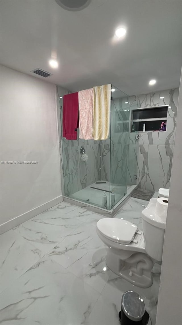 bathroom with toilet and a shower with door