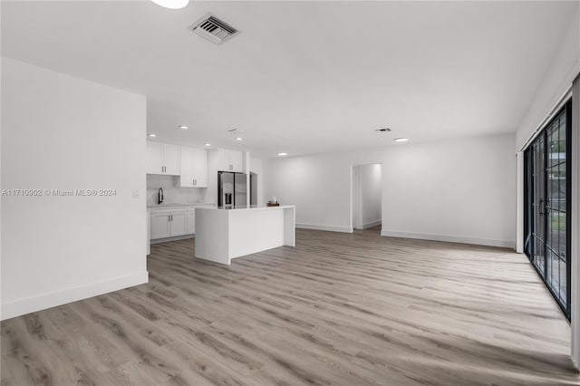 unfurnished living room featuring light wood-type flooring and sink