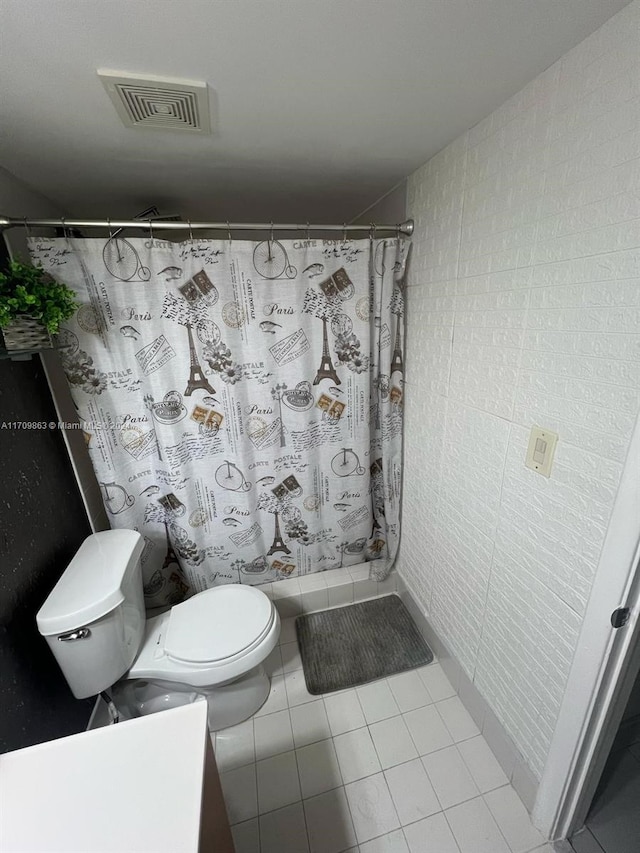 bathroom with tile patterned flooring, vanity, toilet, and walk in shower