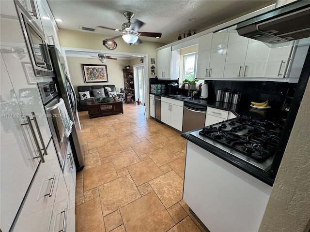 kitchen with white cabinetry, sink, stainless steel dishwasher, backsplash, and extractor fan