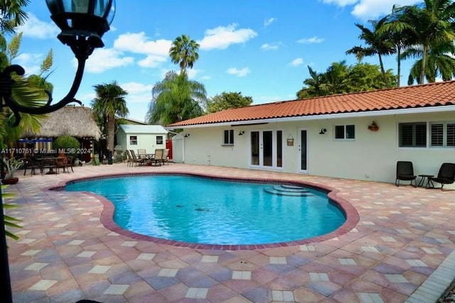 view of swimming pool with a patio area and french doors