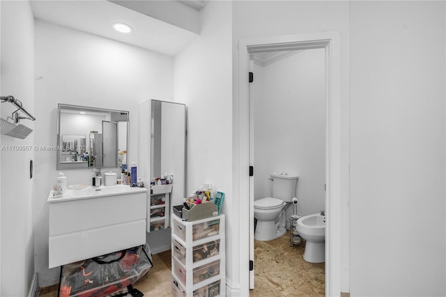 bathroom with vanity, toilet, and a bidet