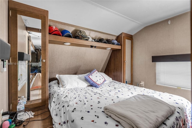 bedroom with hardwood / wood-style floors and vaulted ceiling