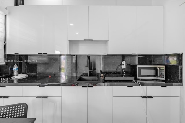 kitchen with white cabinets, tasteful backsplash, and sink