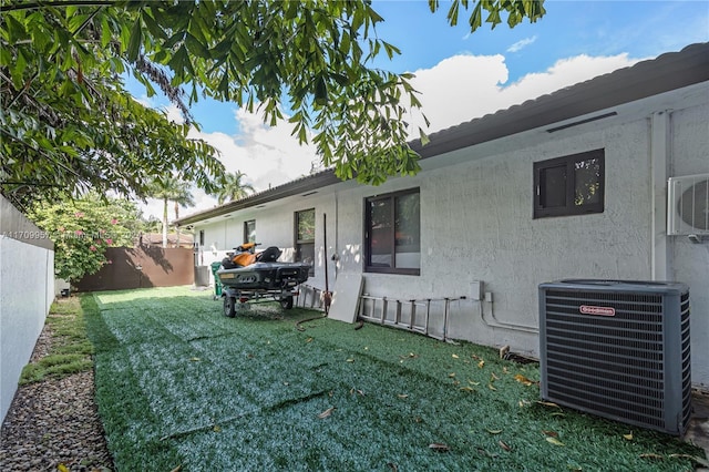 exterior space featuring a yard, cooling unit, and ac unit