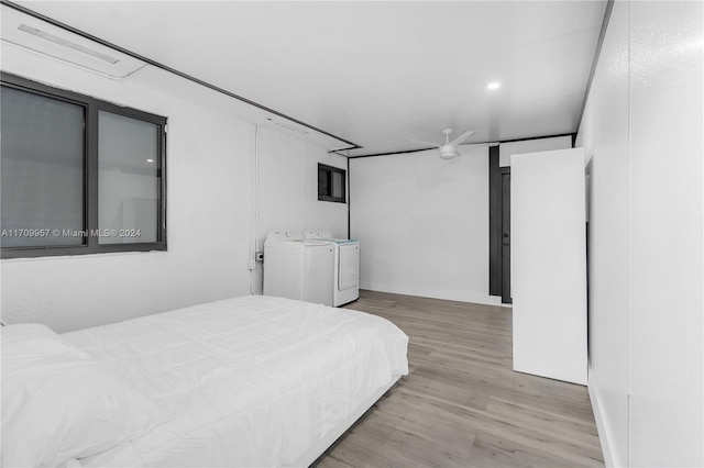 bedroom with washing machine and dryer and light hardwood / wood-style flooring