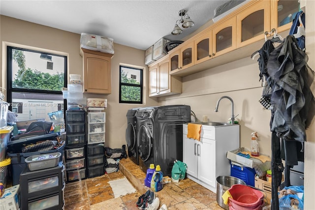 laundry area with washer and clothes dryer, cabinets, a textured ceiling, and sink