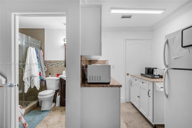 bathroom with decorative backsplash, walk in shower, vanity, crown molding, and toilet