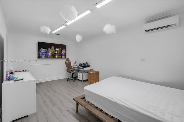 bedroom with a wall mounted air conditioner and wood-type flooring