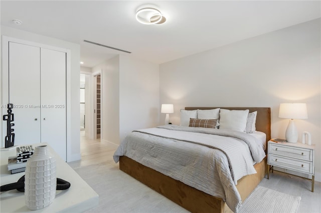 bedroom with light wood-type flooring and a closet