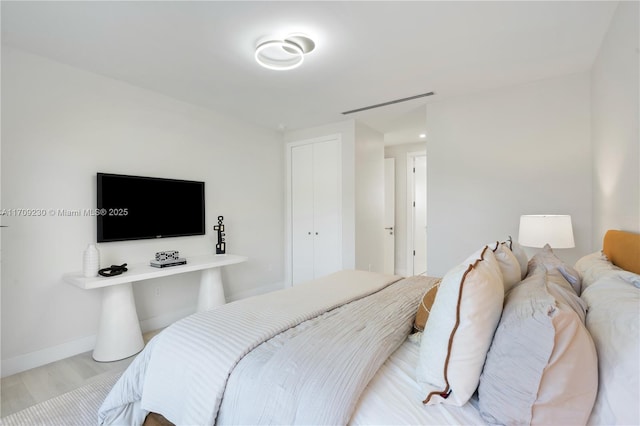 bedroom with light wood-type flooring and a closet