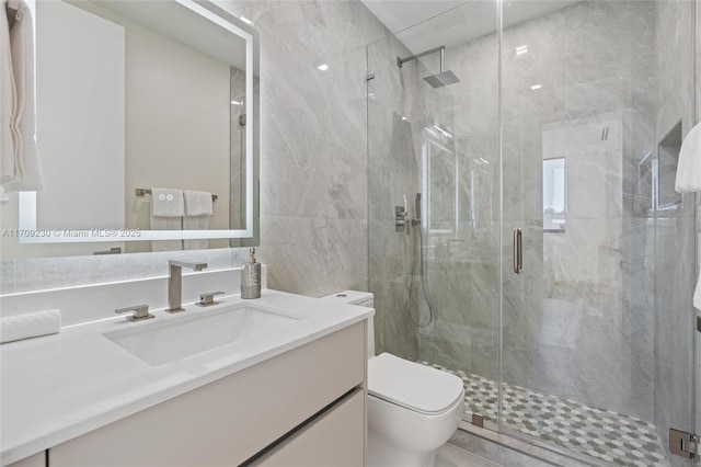 bathroom featuring an enclosed shower, vanity, toilet, and tile walls