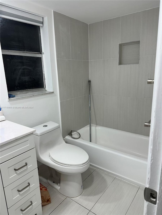 full bathroom featuring tile patterned flooring, vanity, toilet, and tiled shower / bath