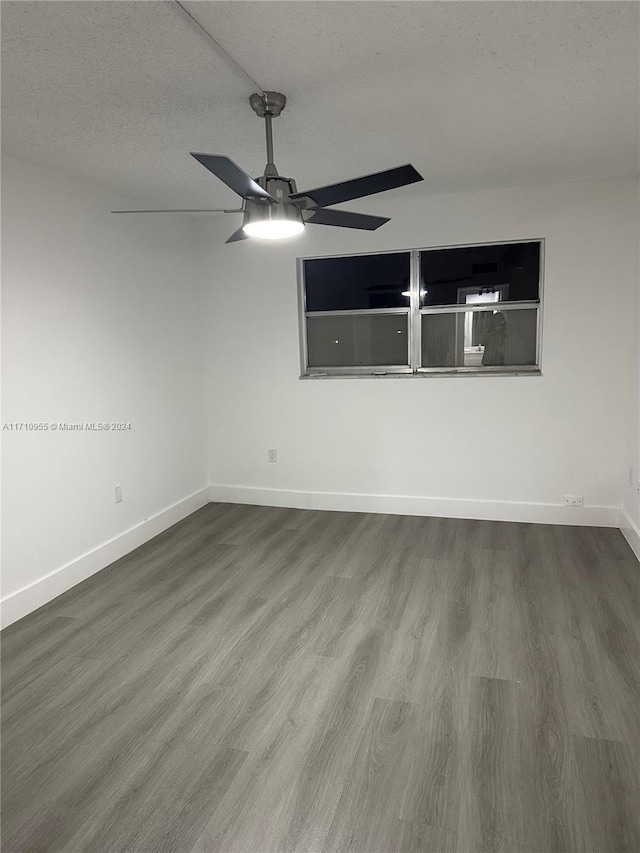 empty room featuring hardwood / wood-style flooring, ceiling fan, and a textured ceiling