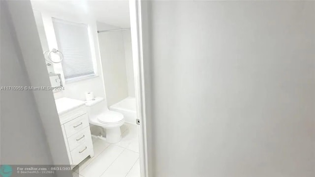 bathroom with toilet, vanity, and tile patterned floors