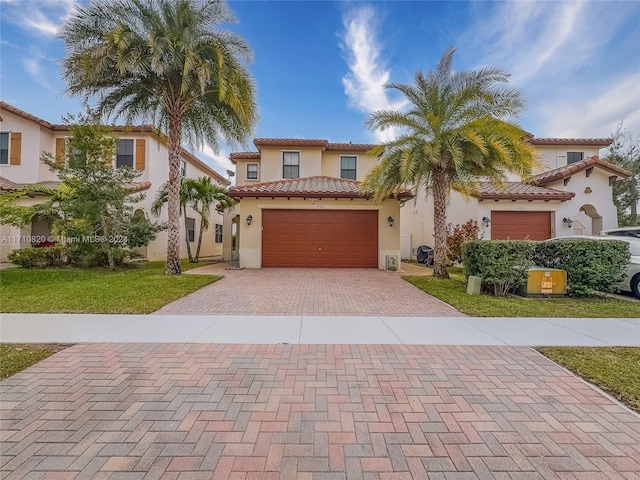 mediterranean / spanish-style home with a front yard and a garage