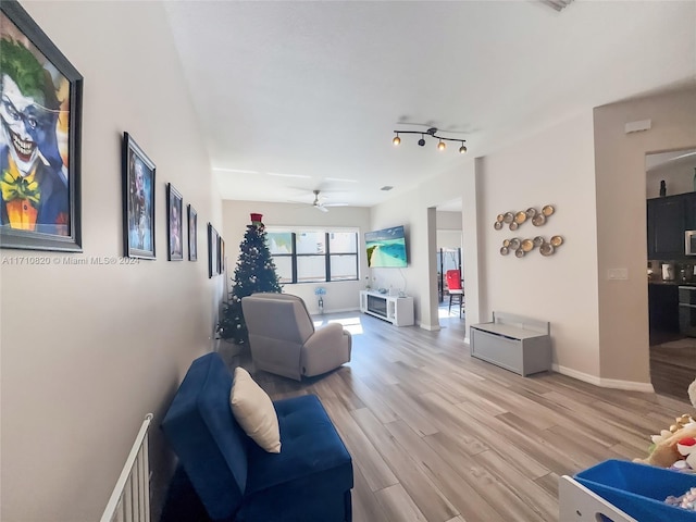 living room featuring ceiling fan and light wood-type flooring