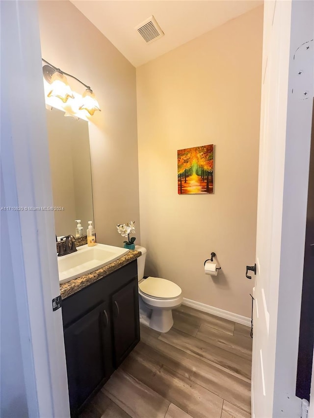 bathroom featuring hardwood / wood-style floors, vanity, and toilet