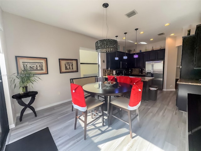 dining room with light hardwood / wood-style flooring and sink