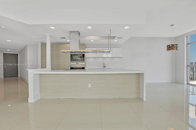 kitchen featuring pendant lighting, white cabinetry, sink, oven, and light tile patterned floors