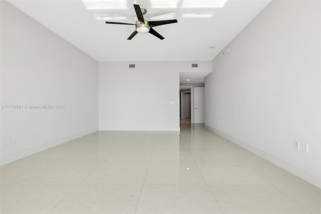 tiled spare room with ceiling fan