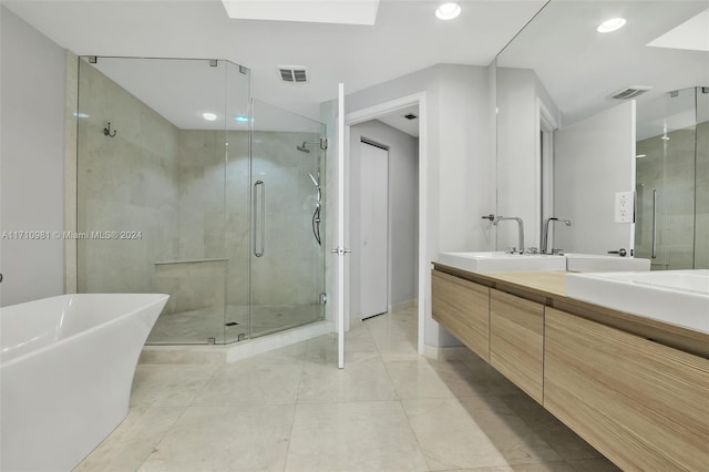 bathroom with vanity and shower with separate bathtub