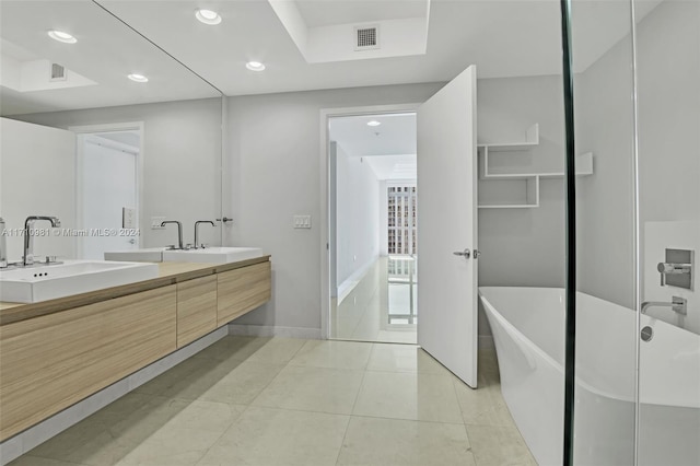 bathroom featuring vanity, a bath, and tile patterned flooring