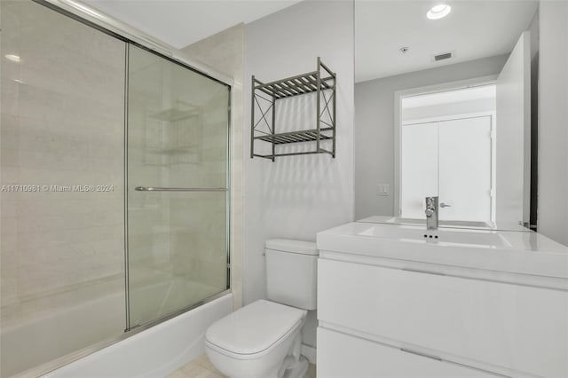 full bathroom with vanity, combined bath / shower with glass door, and toilet