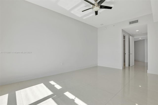 tiled empty room featuring ceiling fan