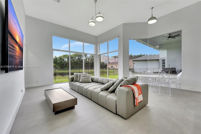 tiled living room featuring a wealth of natural light and baseboards