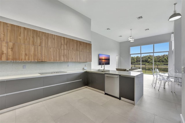 kitchen featuring decorative light fixtures, dishwasher, sink, and kitchen peninsula