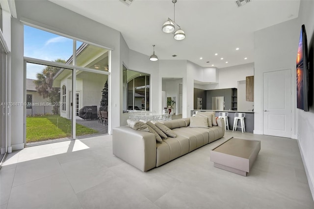 living room with recessed lighting, visible vents, and a high ceiling