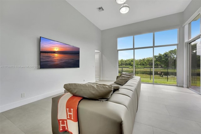 living area featuring baseboards, visible vents, high vaulted ceiling, and a wealth of natural light