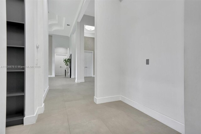 hall featuring light tile patterned floors and built in shelves